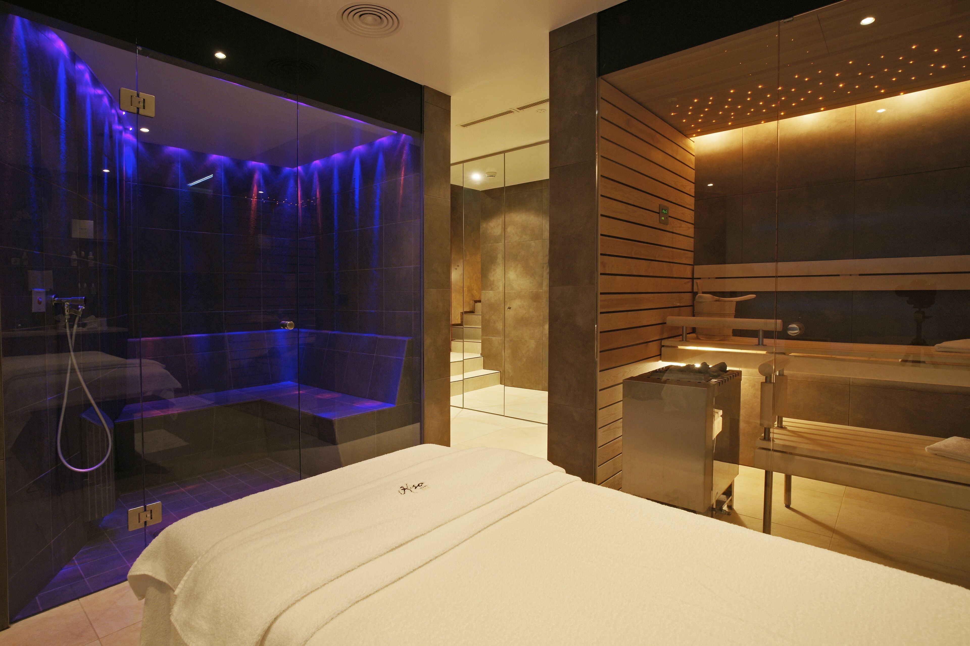 Une salle de bain moderne dotée d’une douche à parois de verre, d’une baignoire et d’un meuble-lavabo avec un miroir.