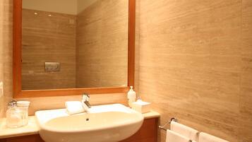 Een moderne badkamer met een grote spiegel, een wastafel, een kastje en een handdoekhouder.