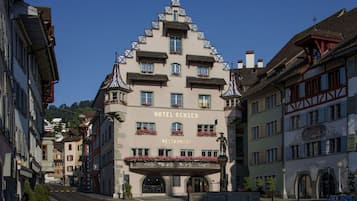 A hotel with a prominent sign reading "HOTEL OCHSEN RESTAURANT" and a traditional architectural style with multiple balconies and a steeply pitched roof.