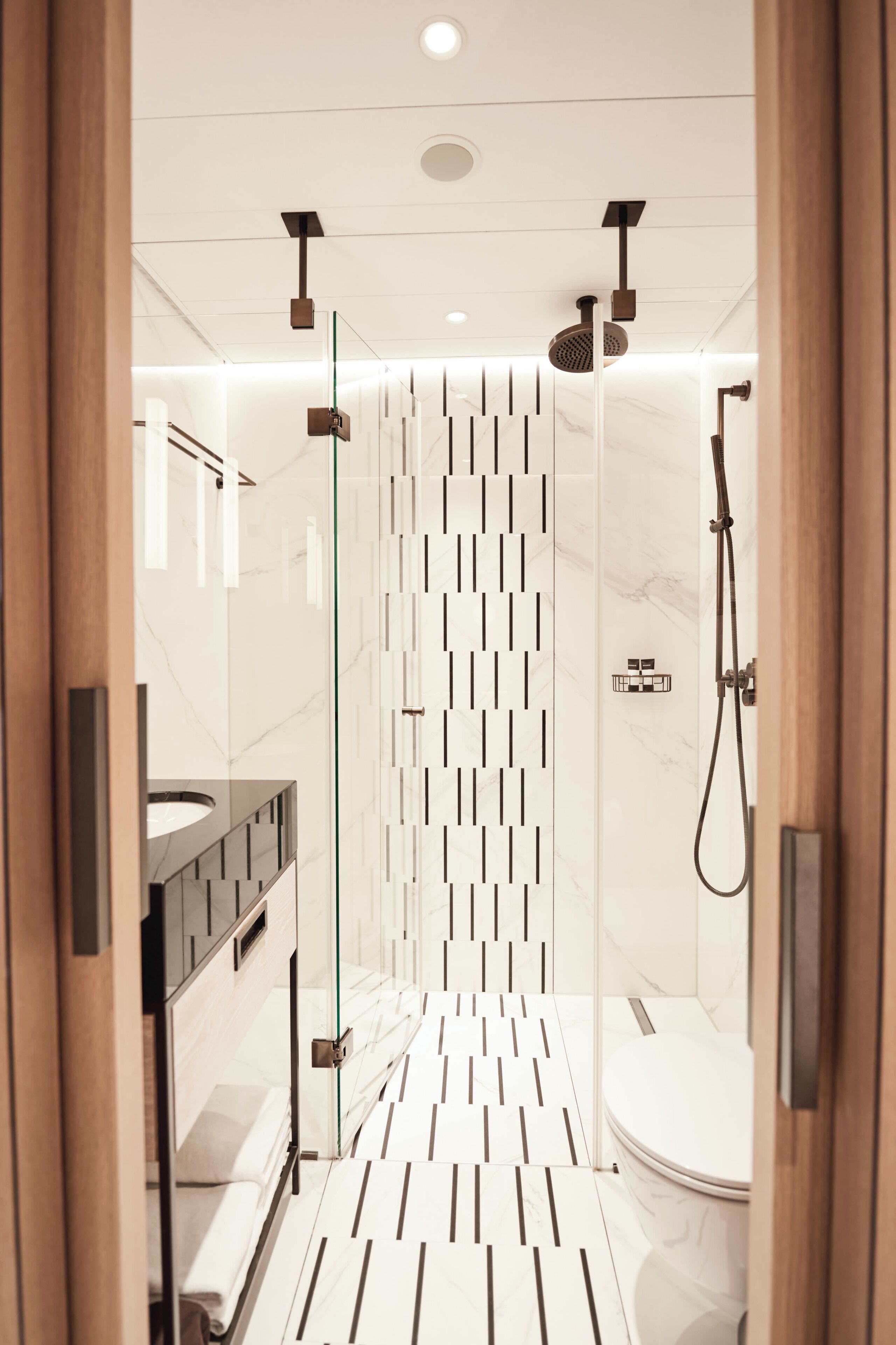 A modern bathroom with a shower, toilet, and vanity.