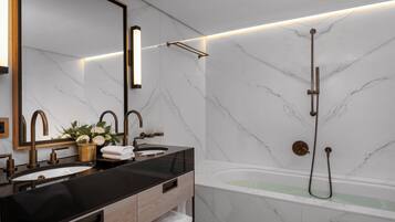 Un baño moderno con dos lavamanos, un espejo grande y una bañera con ducha.