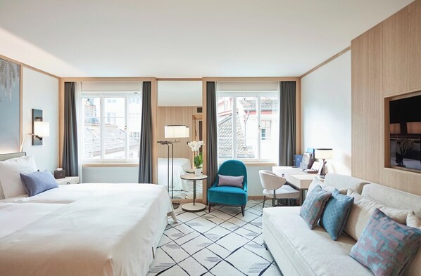 Una habitación de hotel con cama, escritorio, silla y sofá.