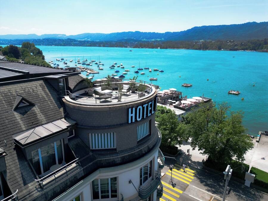 Un hôtel doté d’une terrasse sur le toit offrant une vue sur une baie où sont amarrés des bateaux.