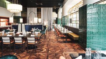 Ein Restaurant mit einem geometrisch gemusterten Boden, Holztischen und -stühlen.