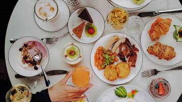 A breakfast table with various dishes including eggs, bacon, and pastries.