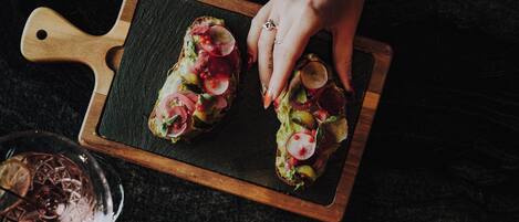 Two slices of toast with toppings on a wooden board.