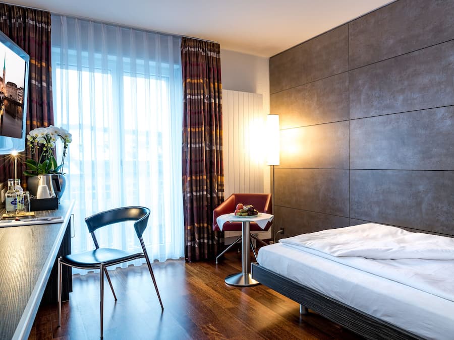 Ropa de cama hipoalergénica y caja de seguridad en la habitación