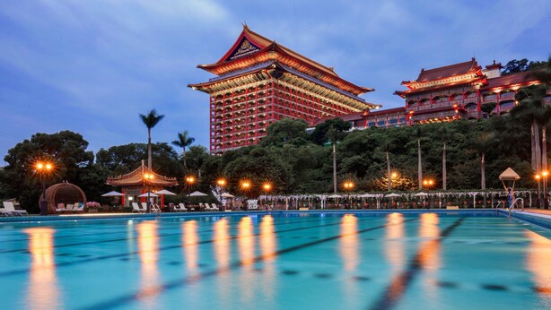 A swimming pool with a traditional building in the background.