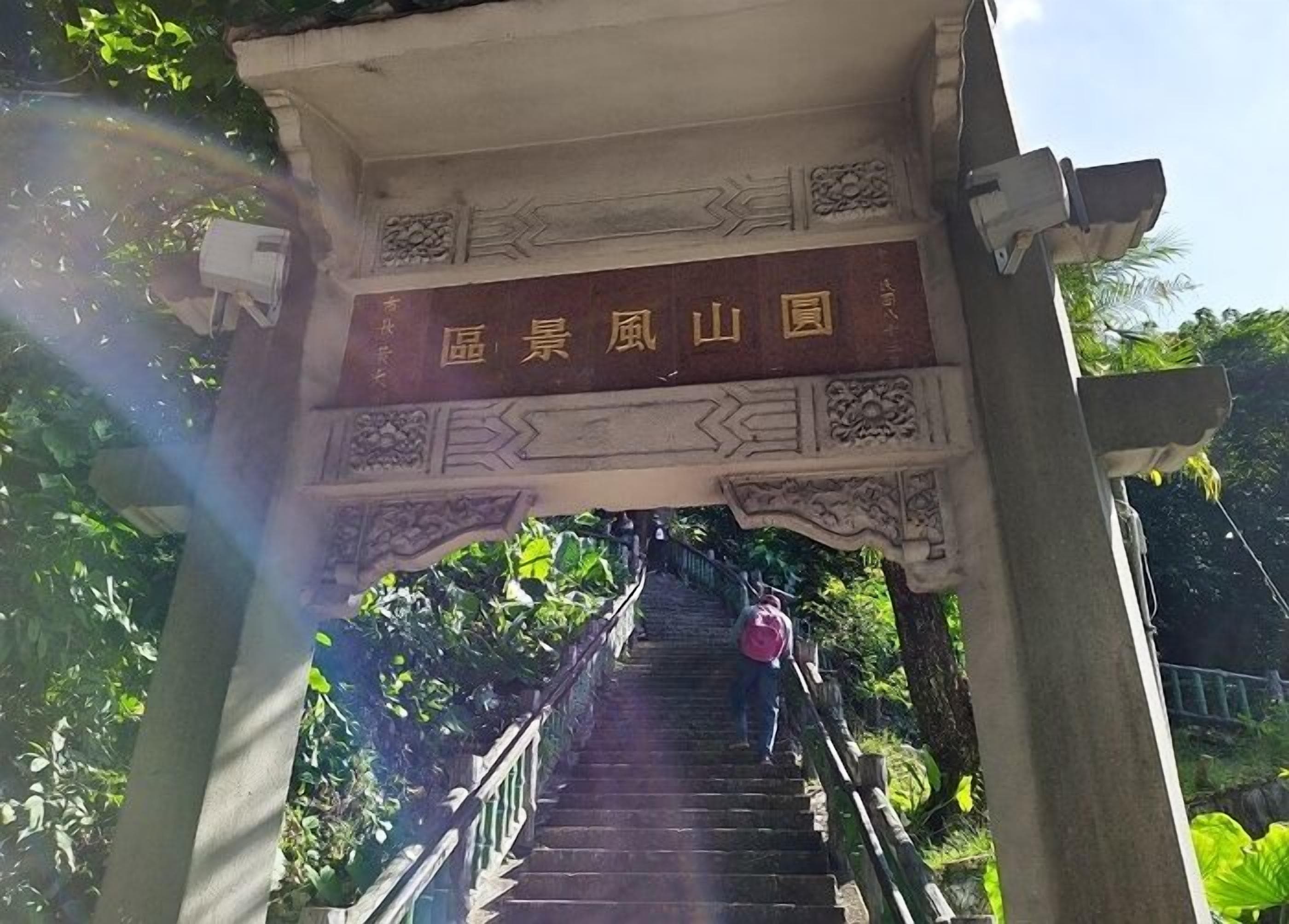 A staircase leading up to a traditional archway with a sign.