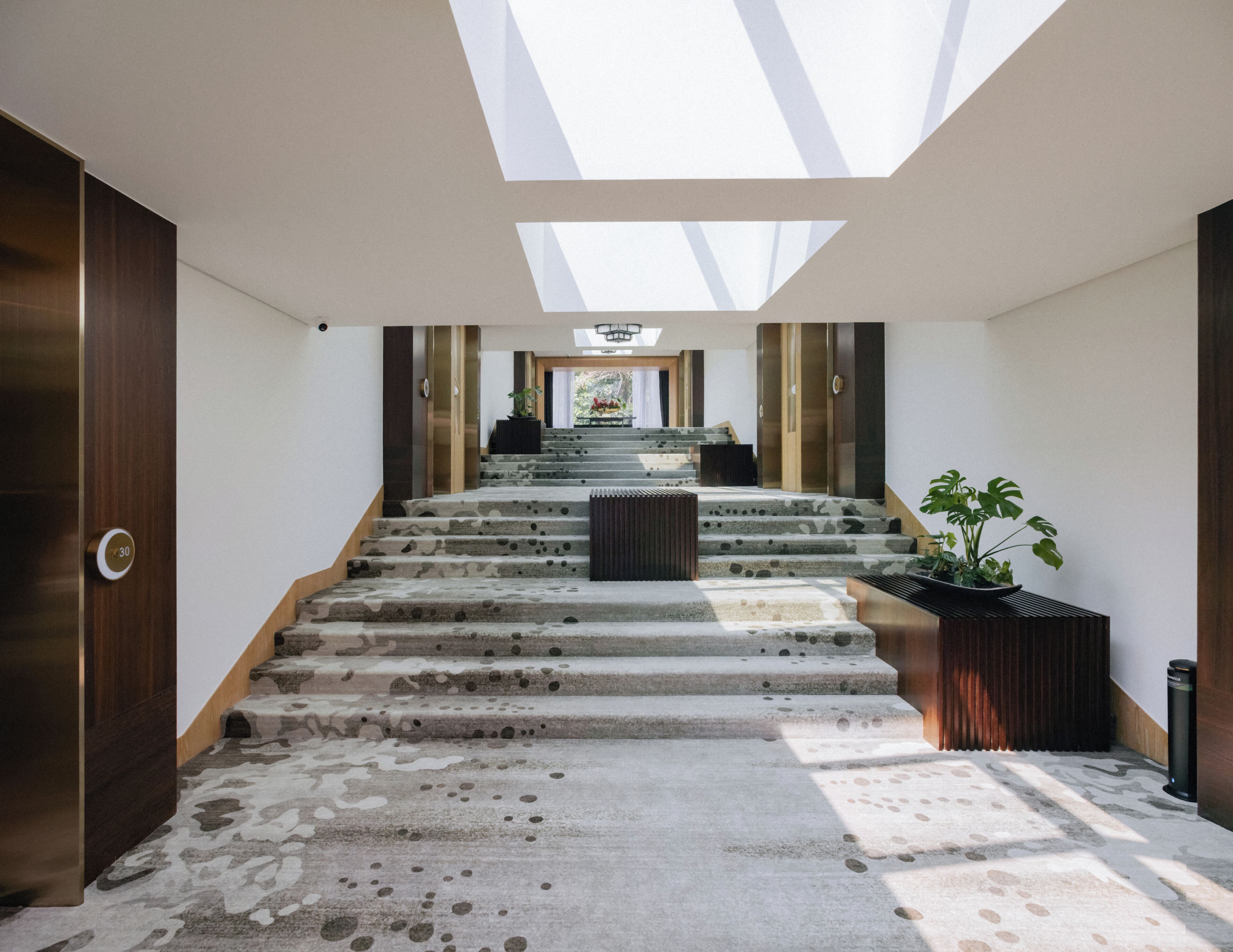 A staircase with a skylight leading to a landing.