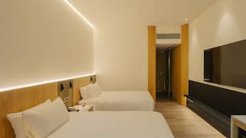 Habitación de hotel con dos camas, televisión y un panel decorativo de madera.