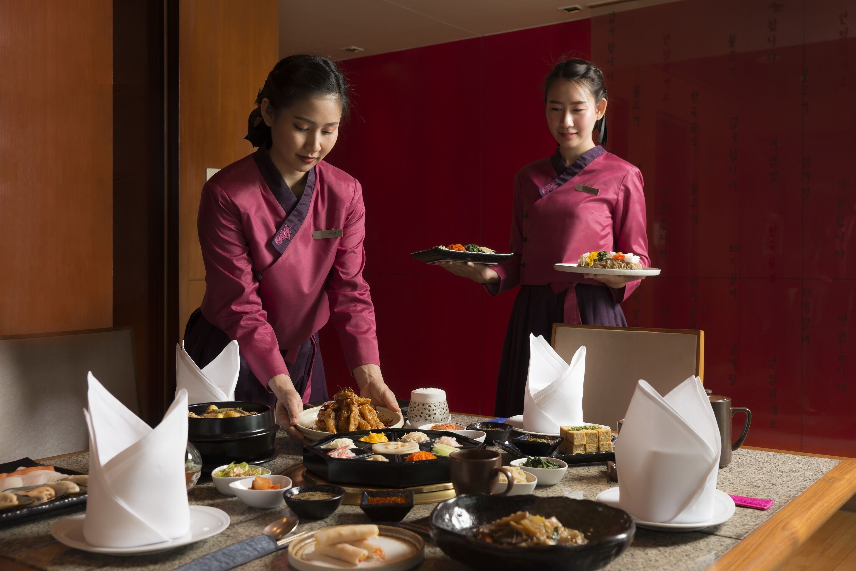 Una mesa dispuesta con diversos platos y un juego de té, lo que sugiere un comedor.
