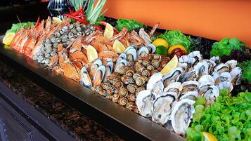 A seafood display with various shellfish and crustaceans, including oysters, clams, and crabs, arranged on a metal tray.