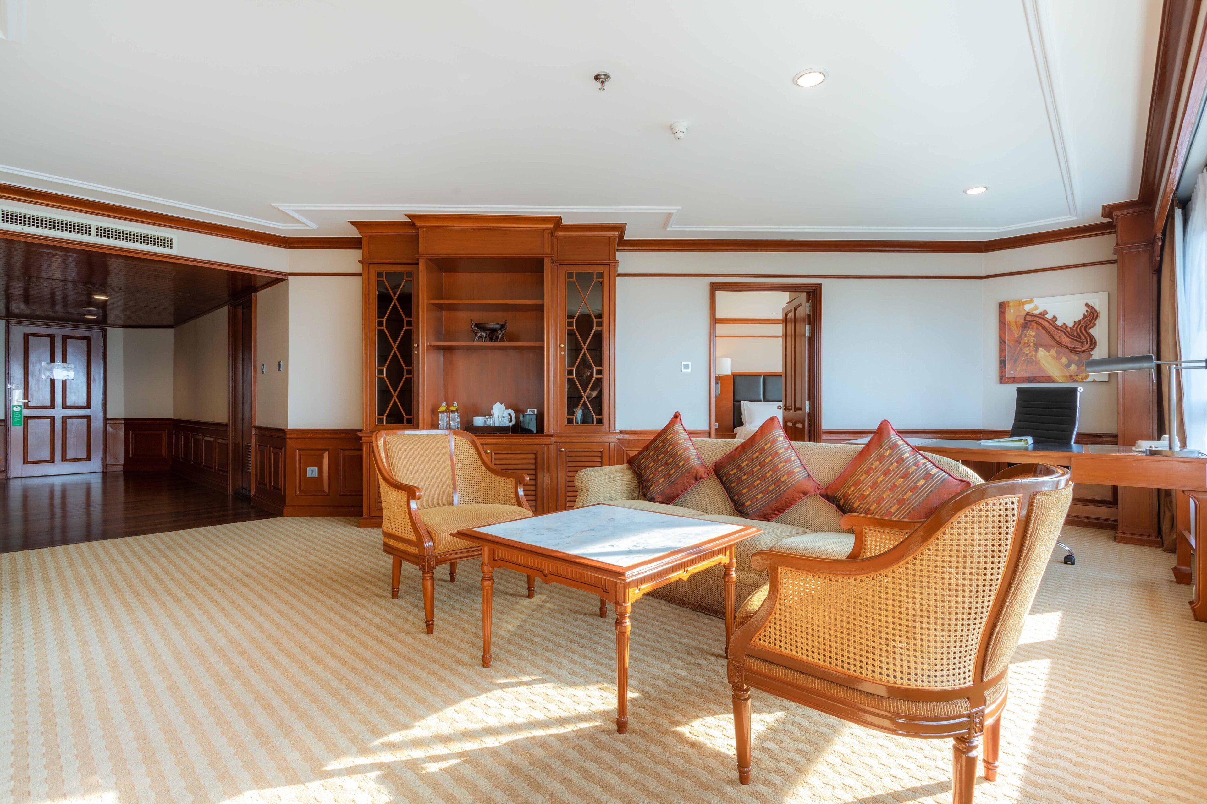 A spacious living room with a large sofa, a coffee table, and a wooden cabinet.