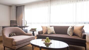 Una sala moderna con un sofá, un sillón y una mesa de centro con manzanas.