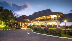 A hotel with a spacious lobby, a second-floor balcony, and a well-lit entrance.