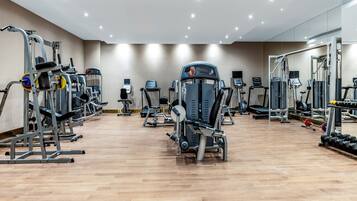 A gym with various exercise machines, treadmills, and free weights.