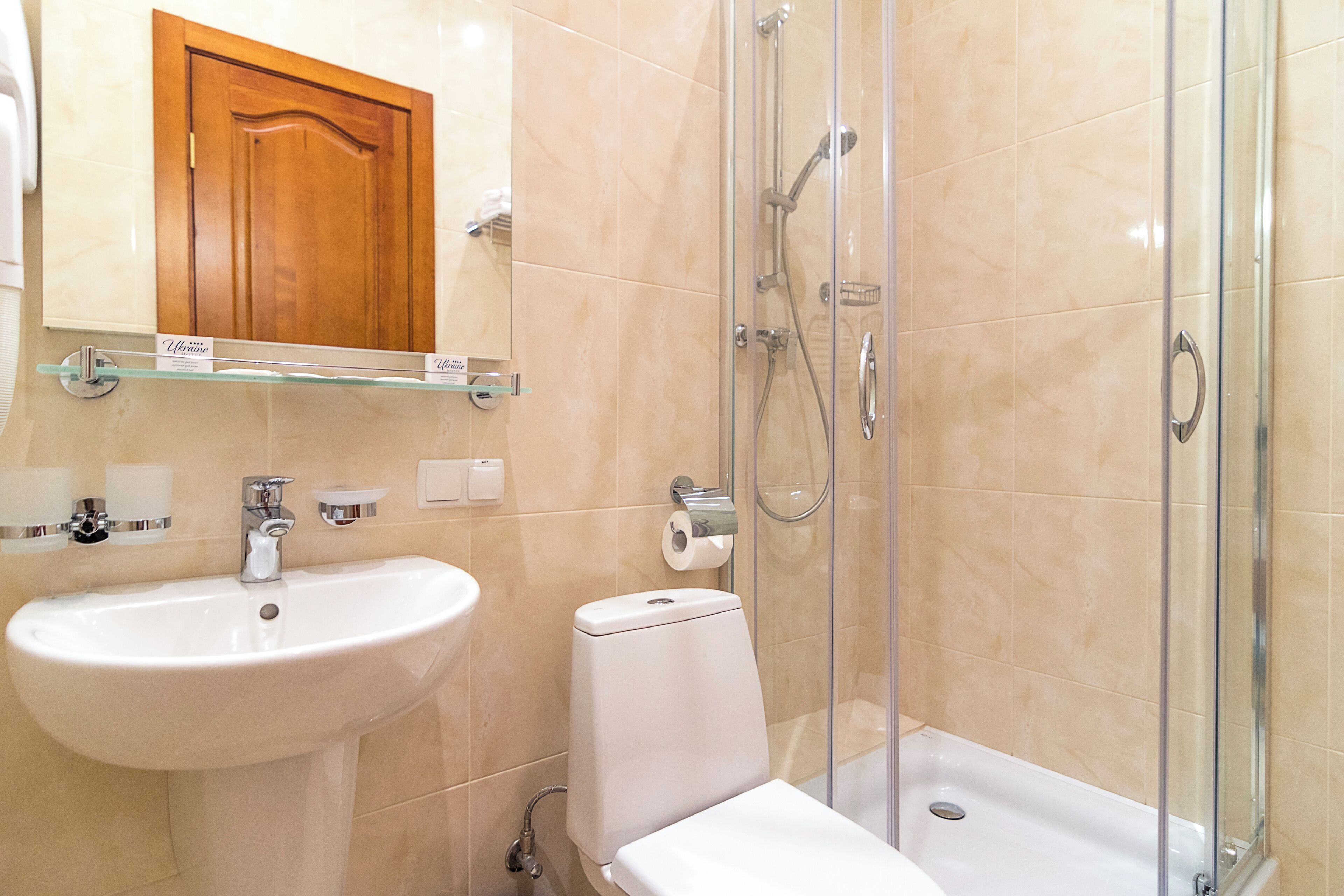 A bathroom with a sink, toilet, and glass-enclosed shower area.