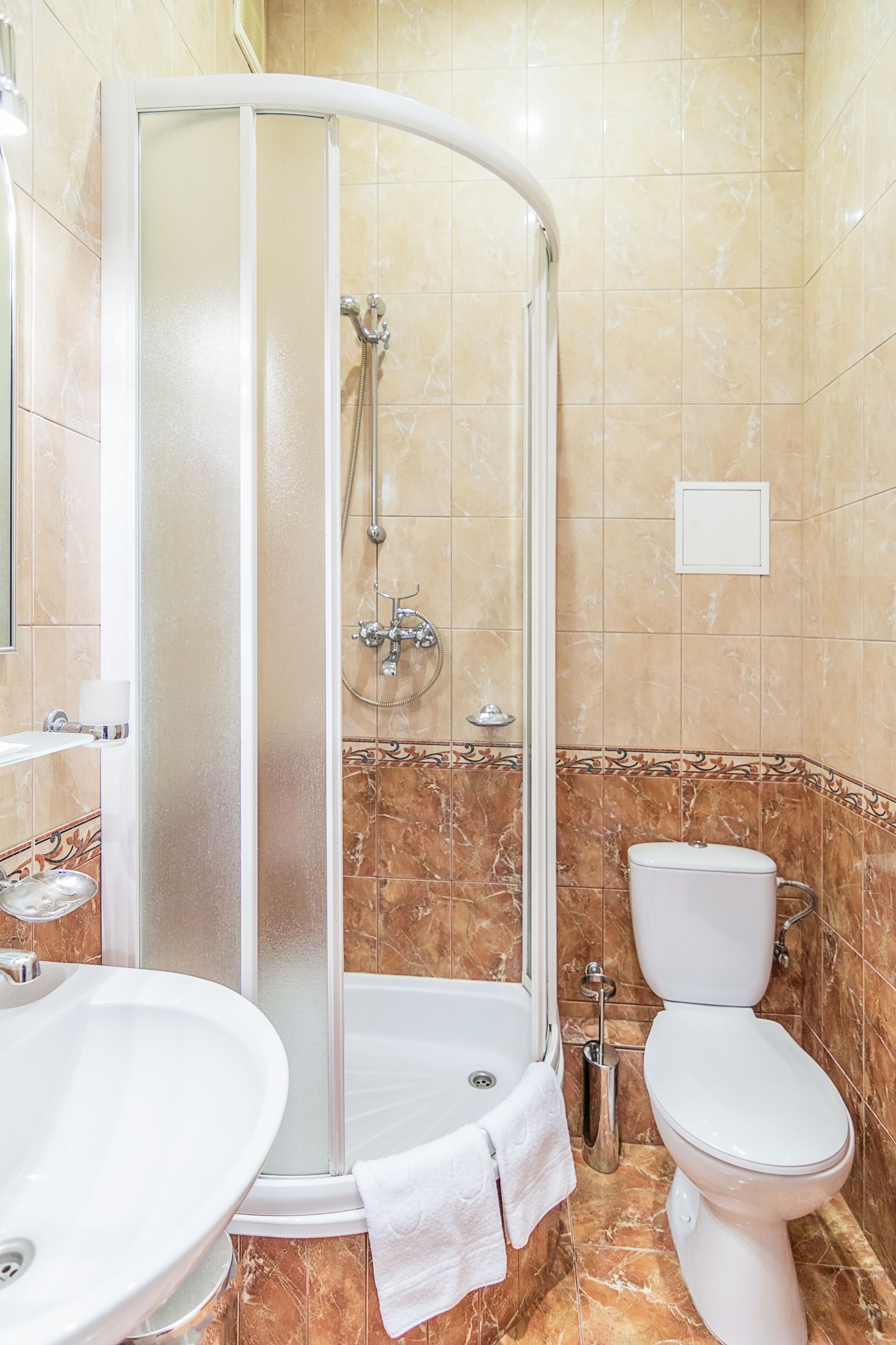 Un baño con ducha de vidrio, lavamanos e inodoro.