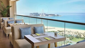 A dining area with a view of the beach and a Ferris wheel. - Al Habtoor Grand Resort, Autograph Collection® (Dubai)