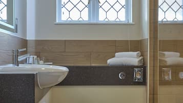 A bathroom with a sink, toilet, and window with a geometric pattern.
