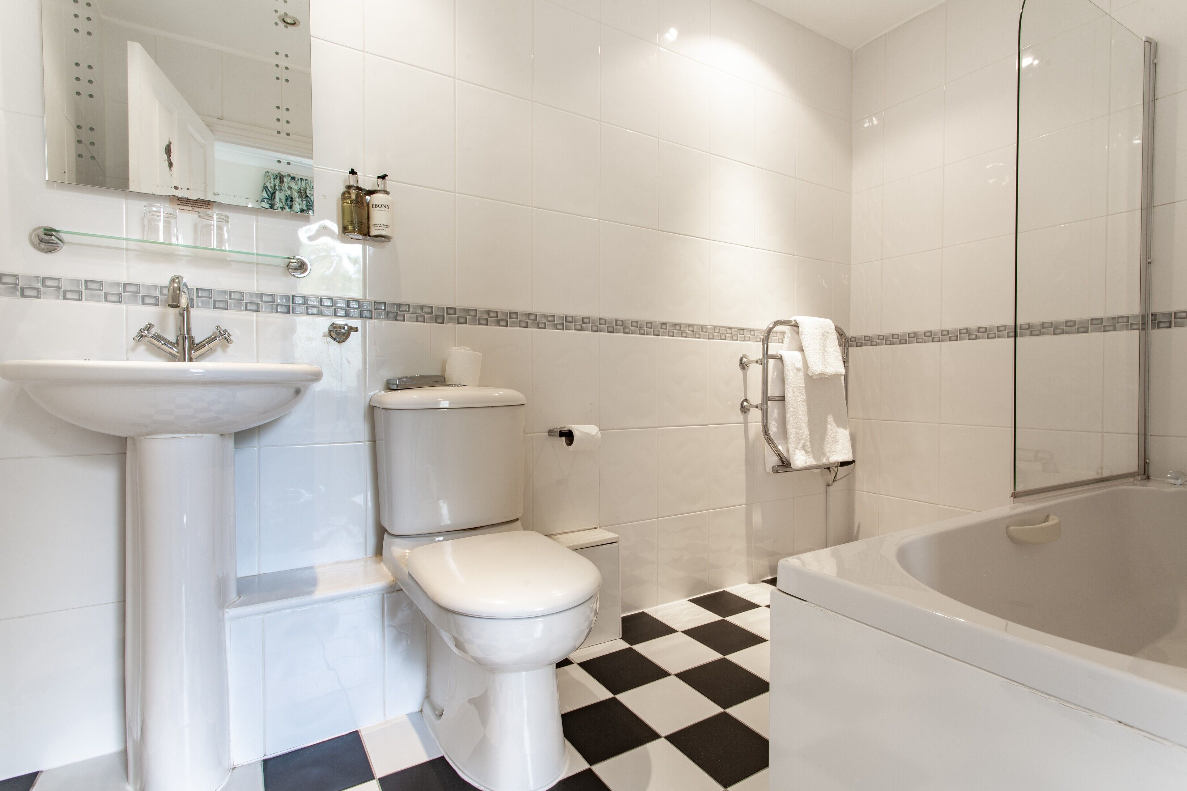 Un baño con lavamanos, inodoro y bañera.