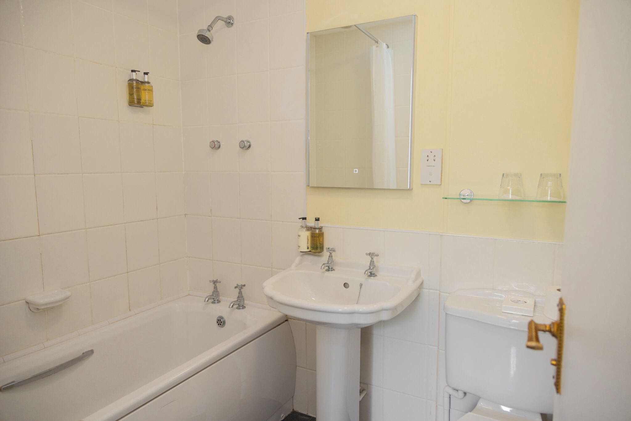 Une salle de bain avec une baignoire, un lavabo, des toilettes et un miroir.