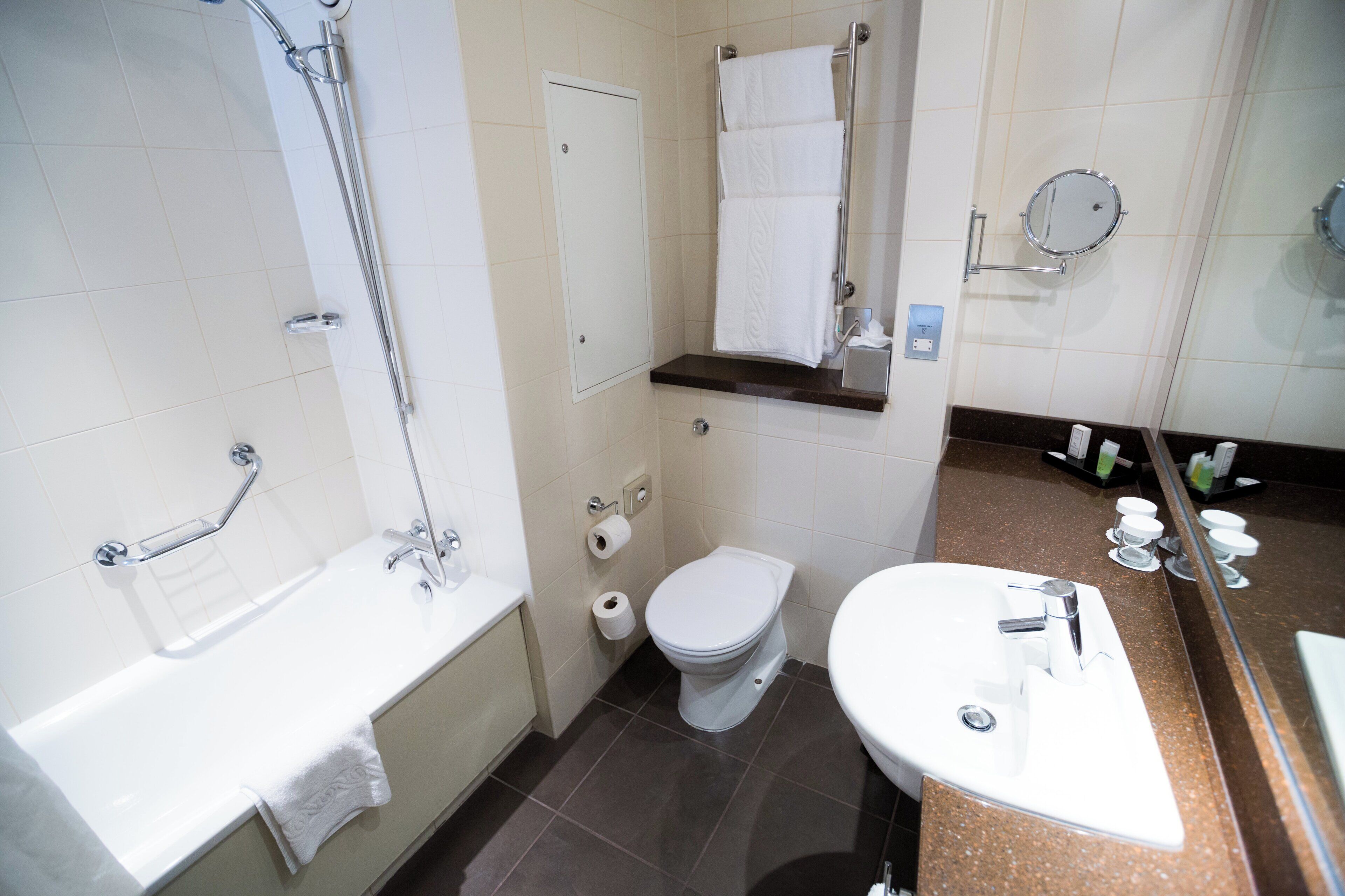 A bathroom with a bathtub, toilet, and sink.