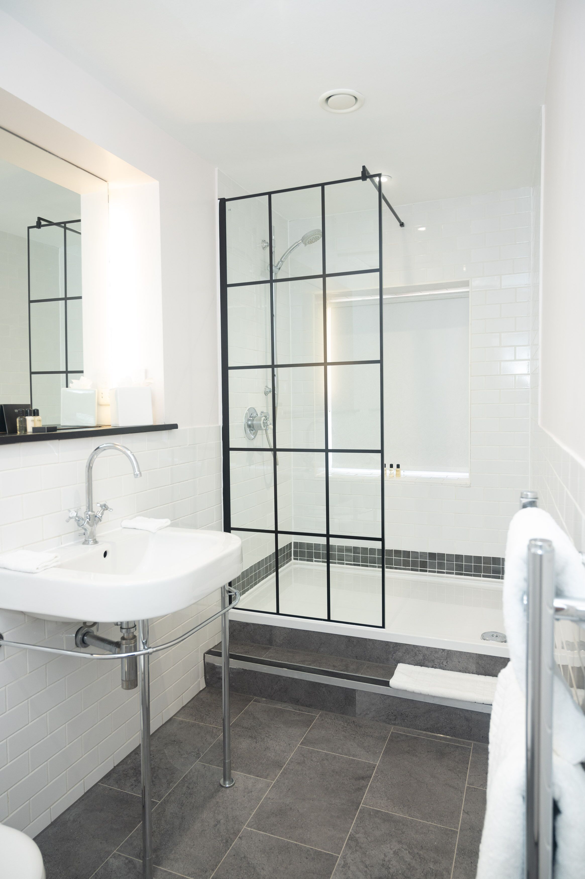 A modern bathroom with a glass-enclosed shower, a white sink, and a bathtub.