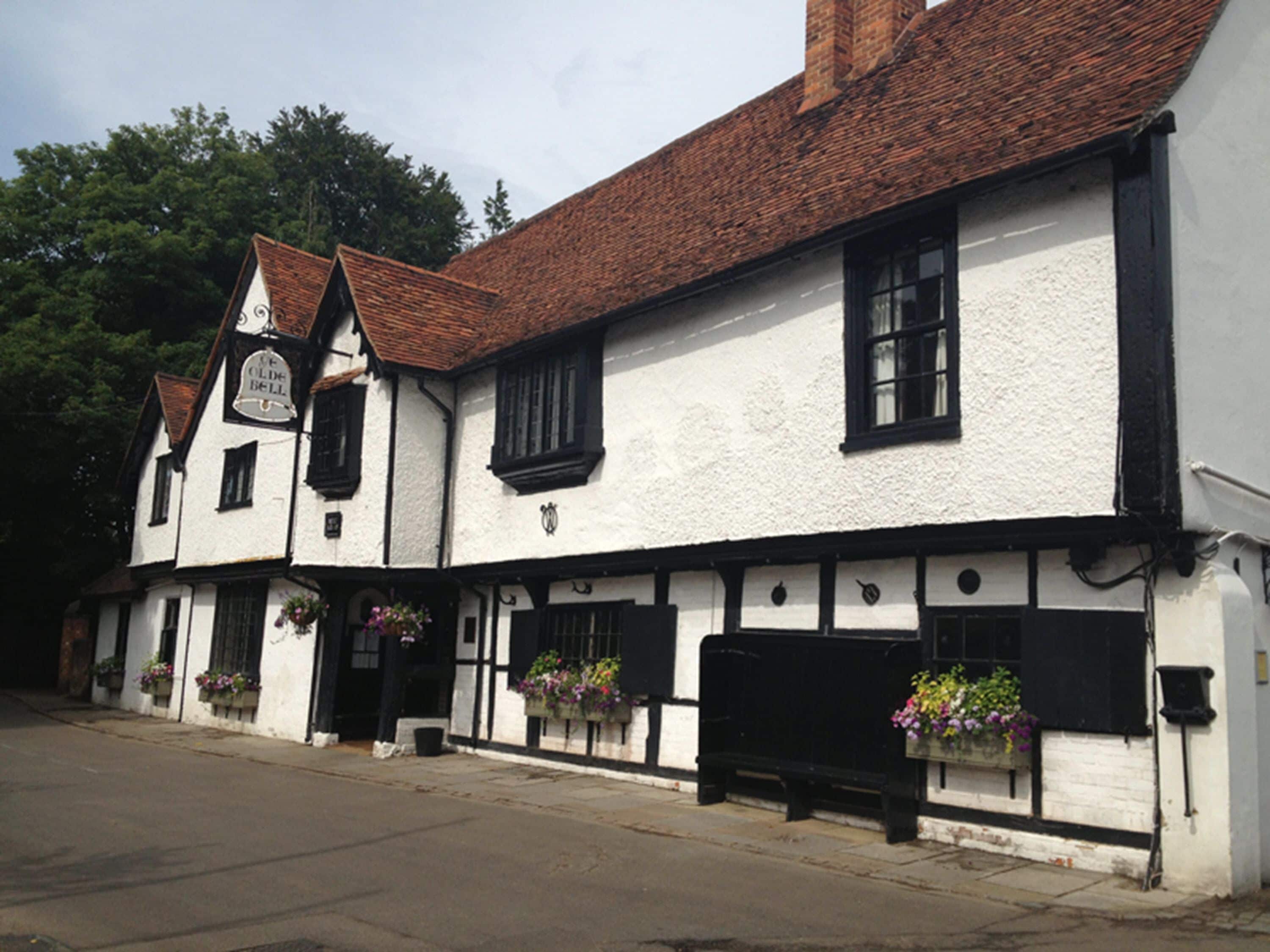 Ein traditionelles Gebäude mit weißer Fassade, schwarzen Fensterrahmen und einem Ziegeldach.