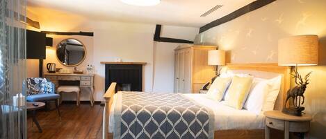A bedroom with a bed, bedside table, lamp, and a mirror.