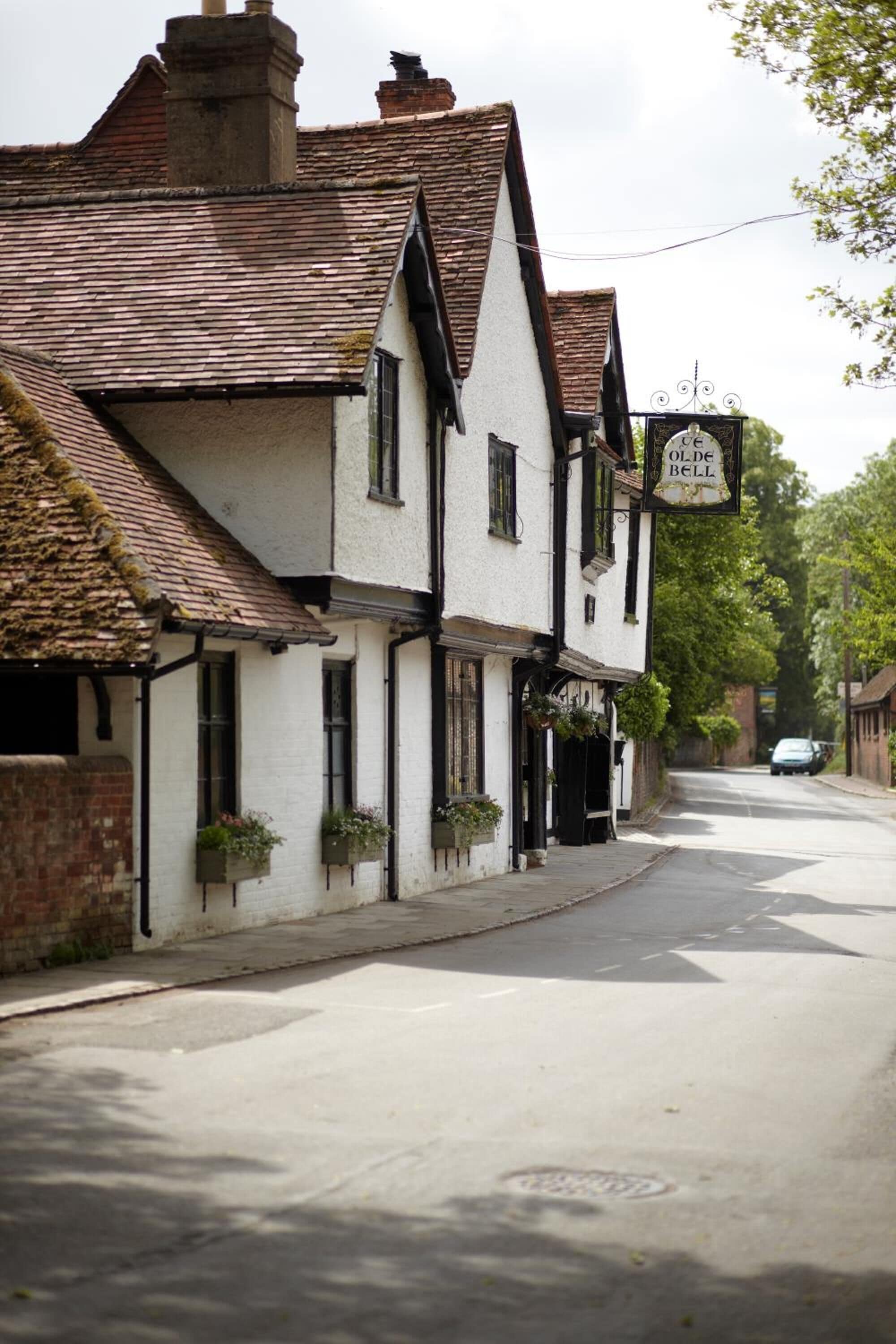 A traditional white building with a black sign reading "Olde Bell."