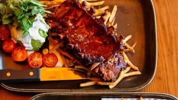 A meal with ribs and fries on a tray.