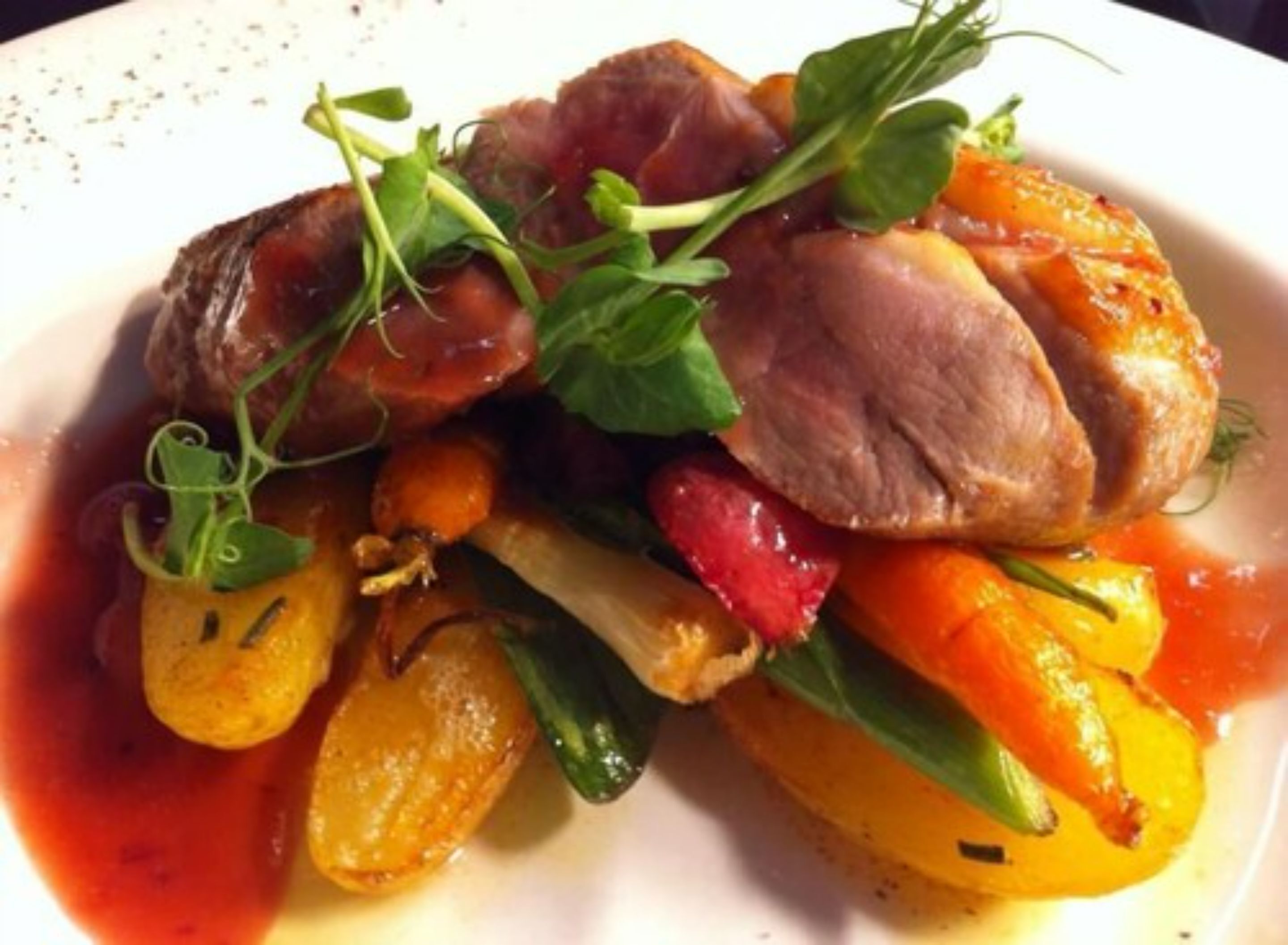 A plate of food with meat, vegetables, and greens.