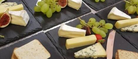 A variety of cheeses and crackers arranged on slate boards.