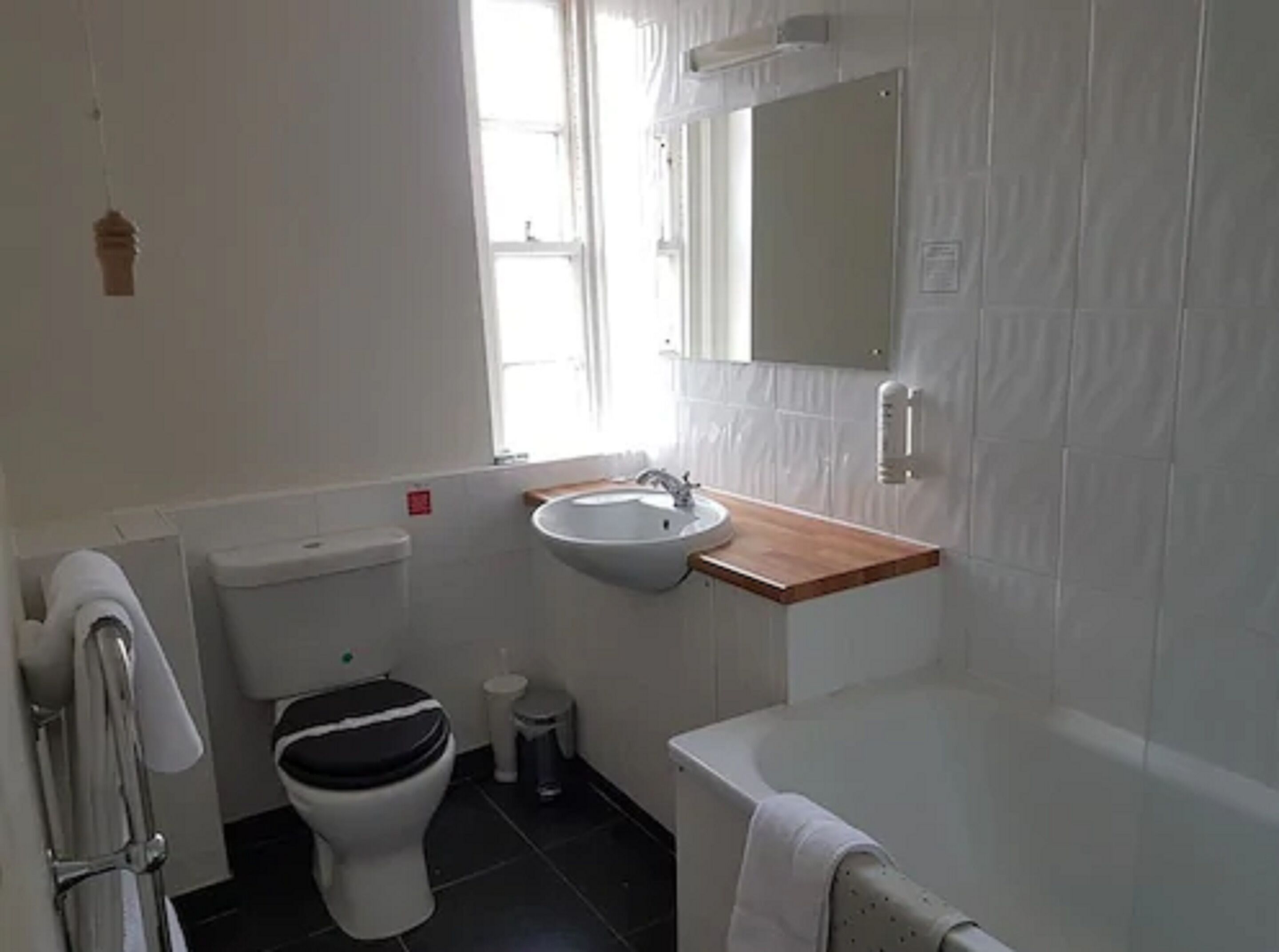 A bathroom with a toilet, sink, and bathtub.