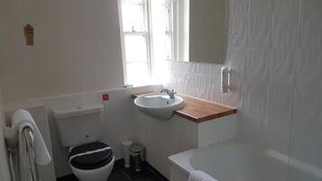 A bathroom with a toilet, sink, and bathtub.