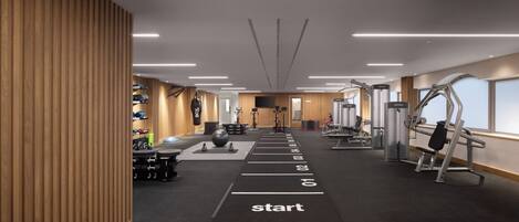 A modern gym with a variety of equipment, a starting line for running, and a large window on the right.