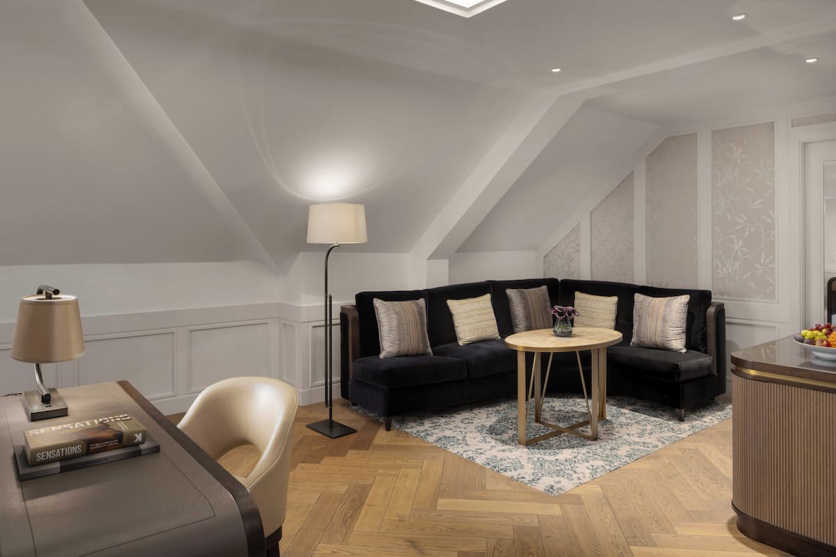A modern living room with a dark sofa, a round coffee table, and a floor lamp.