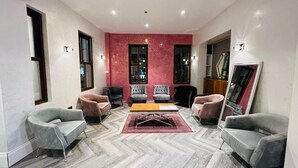 A modern living room with a herringbone floor, two sofas, a coffee table, and a fireplace.