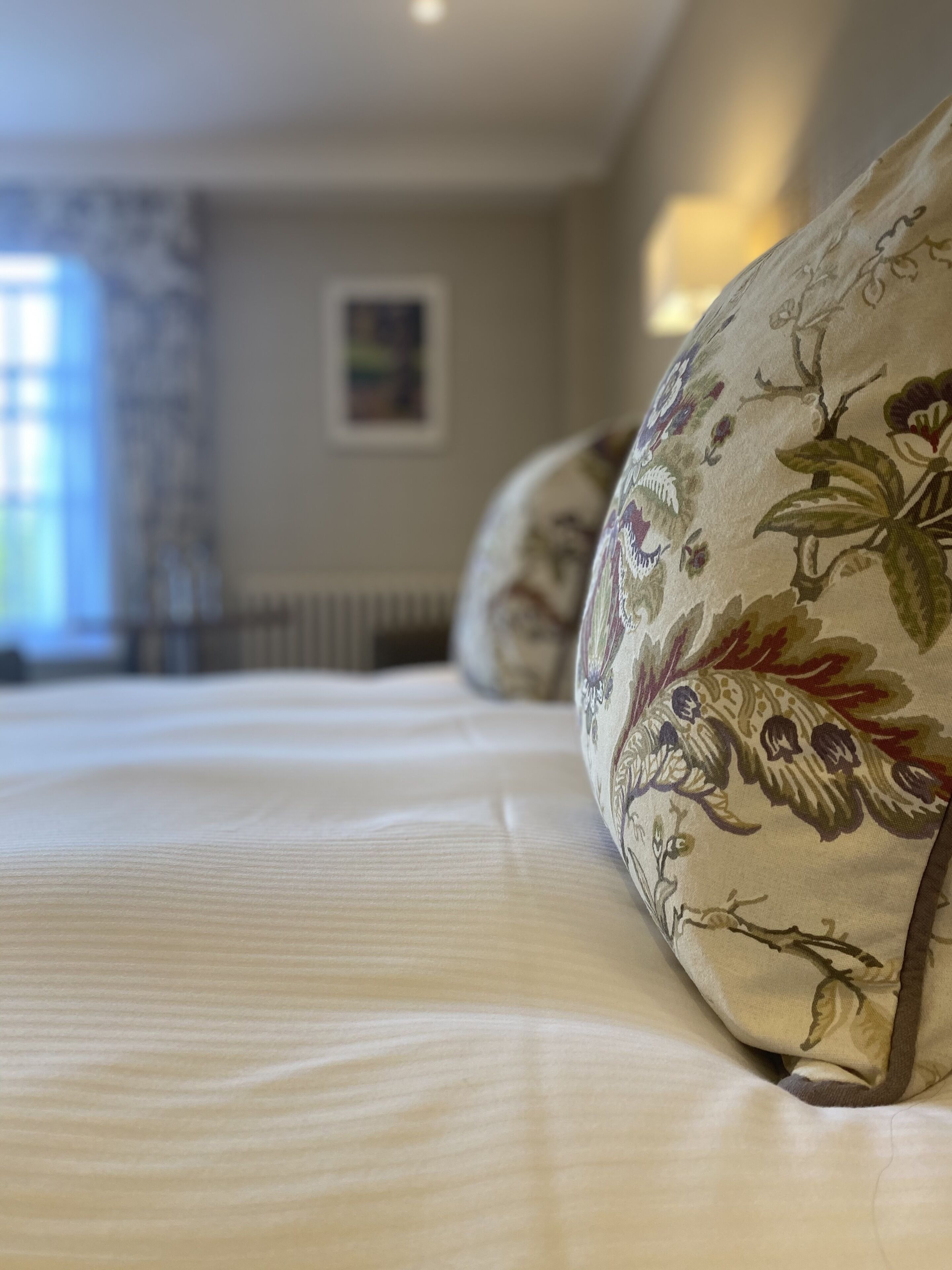 A bed with floral-patterned pillows and a neatly made bedspread.