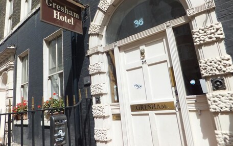 A hotel entrance with a sign reading "Gresham Hotel" and a door labeled "GRESHAM."
