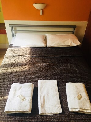 Tabla de planchar con plancha y ropa de cama