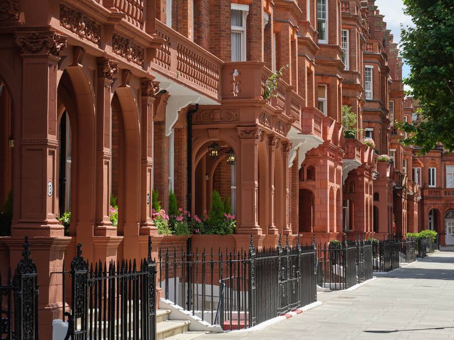 A row of red brick buildings with ornate architectural details, including columns and decorative moldings.
