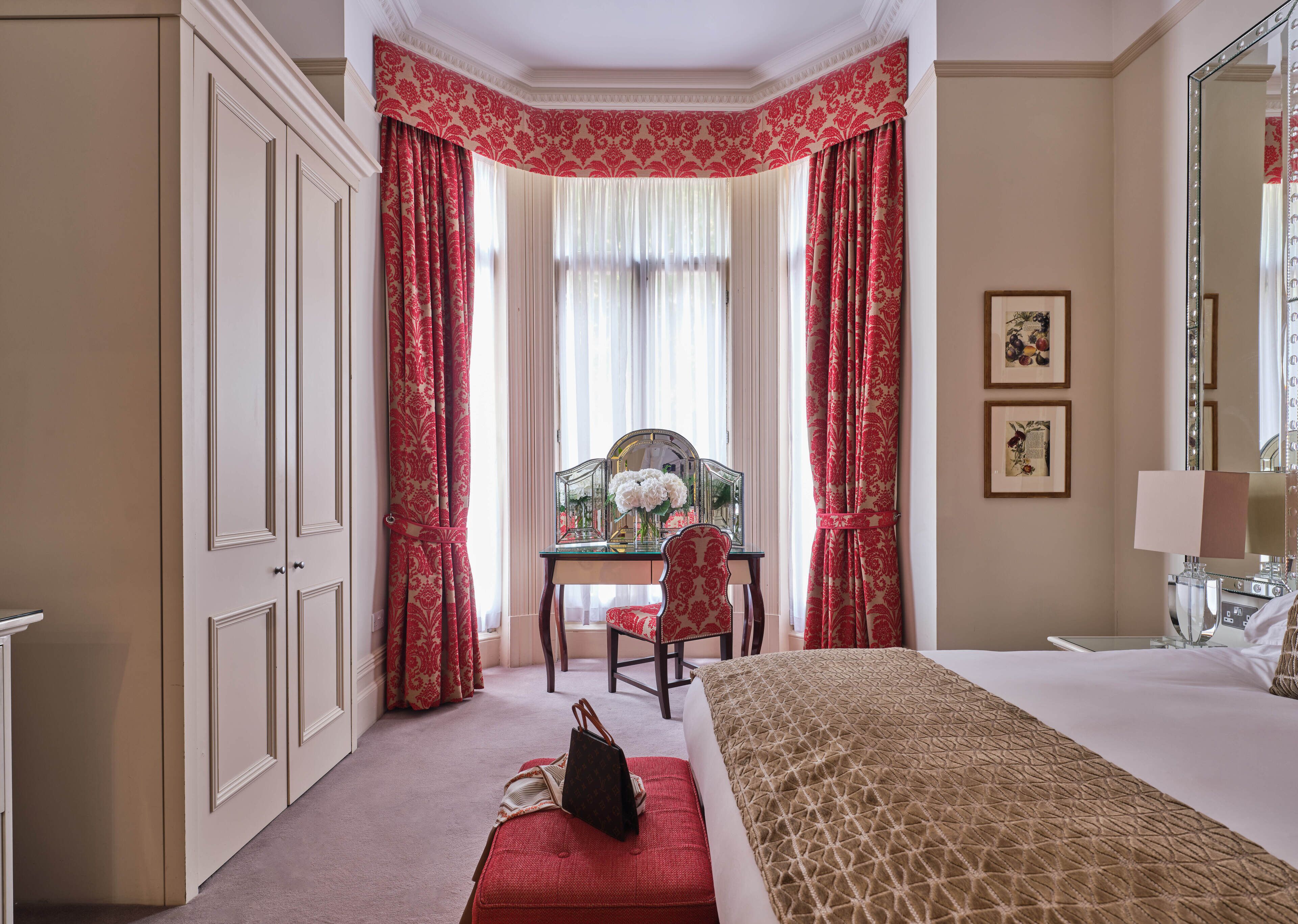 Habitación de hotel con una cama grande, un escritorio con una silla y un espejo grande.