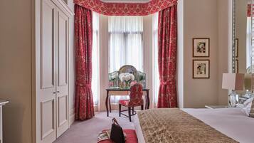 Habitación de hotel con una cama grande, un escritorio con una silla y un espejo grande.