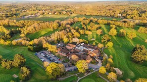 An aerial view of a golf course with a clubhouse and parking lot. - Meon Valley Hotel, Spa & Golf (Southampton)
