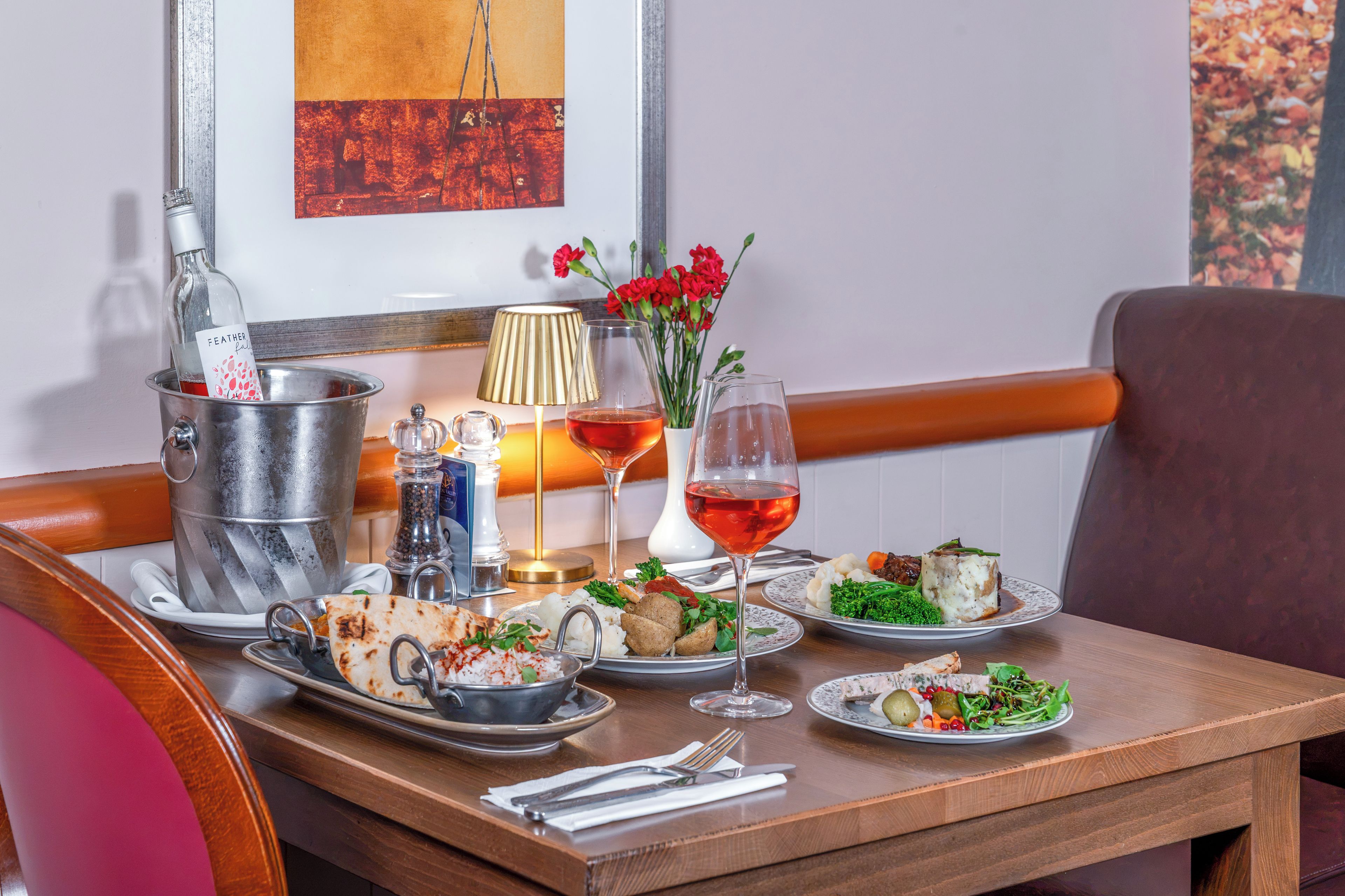 A dining table set with various dishes, a bottle of wine, and a lamp.