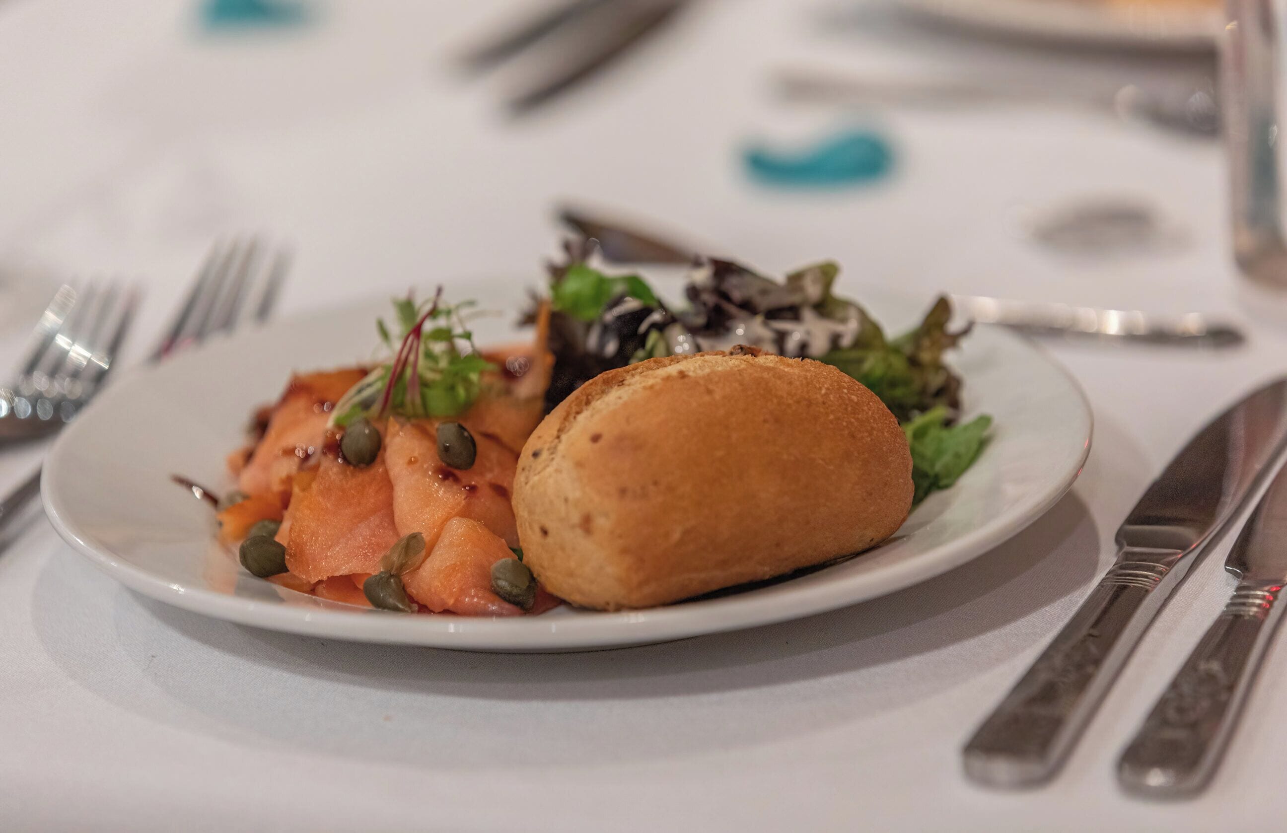 A plate with food, a fork, and a knife on a table.