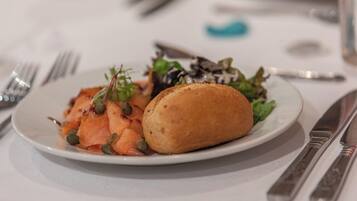 A plate with food, a fork, and a knife on a table.